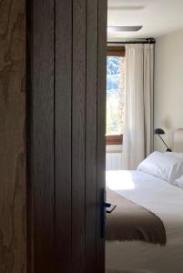 里亚尔普Les Nous Hotel的一间卧室设有一张床和一个窗口
