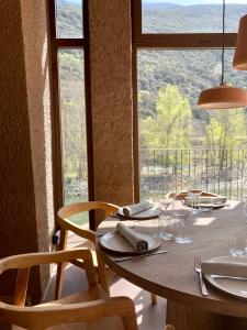 里亚尔普Les Nous Hotel的餐桌、椅子和美景窗户