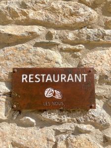 里亚尔普Les Nous Hotel的石墙边的标志