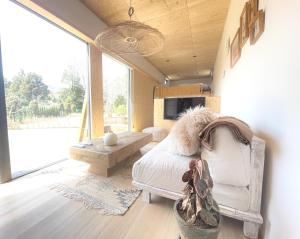 山中湖村GLANSTELLA CABIN Fujiyamanakako的一间卧室配有一张床、一张沙发和一张桌子