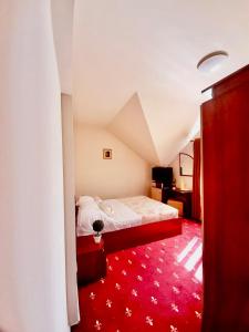 马马亚Vila Miluna的一间卧室配有一张床,铺有红色地毯