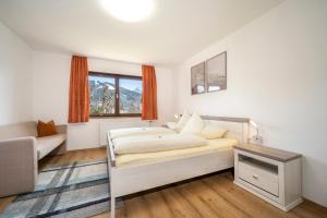 拉德施塔特Haus Kindler的一间卧室配有一张床、一张沙发和一个窗口