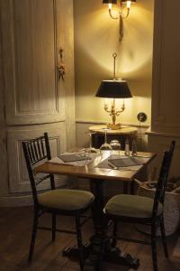 奥比松Hôtel de Colbert的餐桌,配有两把椅子和一盏灯