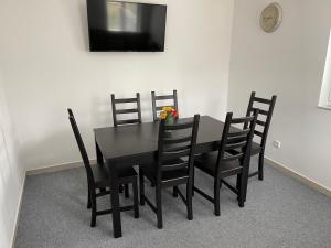 比托福Chata Marine的一张黑色餐桌、黑色椅子和电视