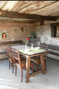 坎加斯-德奥尼斯Casa Rural El Cotu en Cangas de Onís的一张带椅子的木桌和一个花瓶