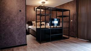 德里默伦Hotel Biesbosch的一间设有床铺和黑书架的房间