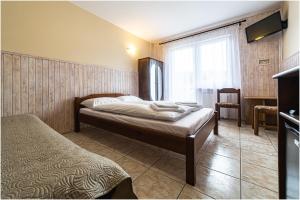 波别罗沃Willa Marlin的一间卧室配有一张床、一张书桌和一个窗户。