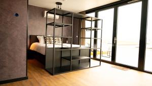 德里默伦Hotel Biesbosch的卧室配有黑书架,毗邻一张床