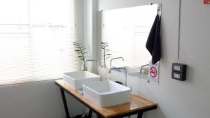 清迈戴兹旅舍的浴室设有木桌上的两个盥洗盆