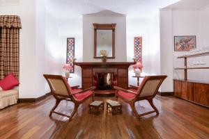 努沃勒埃利耶Scottish Planter Bungalow- Thema Collection的客厅配有两把椅子和壁炉