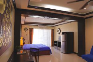 七岩THOMLEK Guesthouse的一间卧室配有一张床、一台冰箱和一张桌子