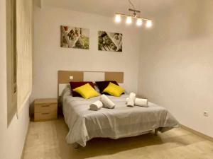 EsteponaChicflat Avenida España Ideal para familias的一间卧室配有黄色和红色枕头的床