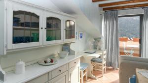 努奥罗Welcomely - Casa Ortobene的厨房配有白色橱柜、桌子和书桌。