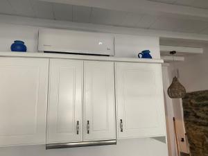 提诺斯BIANCO BLUE的厨房配有白色橱柜和笔记本电脑。
