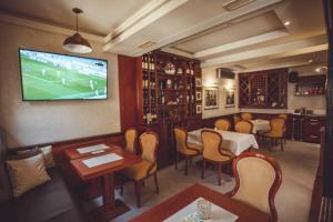 巴尼亚卢卡Provence rooms的餐厅设有桌椅和墙上的电视
