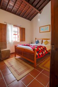 BiscoitosQuinta dos Reis的卧室位于客房的角落,配有一张床
