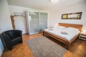 斯洛文尼亚科尼采Apartment pri Povhih的一间卧室配有一张床和一张黑椅