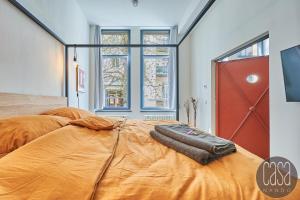 莱比锡casanando prestige Suites - HiFi Erlebnis in Zoo - und Citylage的一间卧室配有一张带橙色棉被的大床
