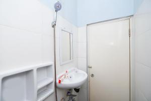 梭罗Super OYO 1414 Paviliun Permata的白色的浴室设有水槽和镜子