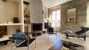 阿雅克修CASA DI ARTISTI AJACCIO - Holiday Homes - Classé 5 étoiles - EXCEPTIONNEL的客厅配有椅子、桌子和电视