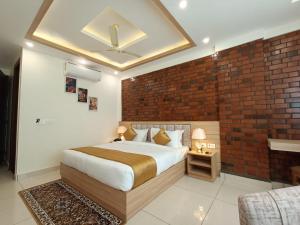 德拉敦Hotel Royal Palm Dehradun的一间卧室设有一张床和砖墙