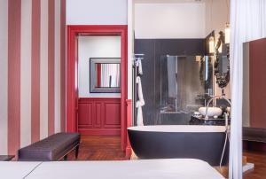 波尔多Le Palais Gallien Hôtel & Spa的带浴缸的浴室和红色门廊