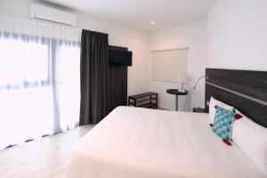 拉佩讷叙尔于沃讷Appart' Hotel La Girafe Marseille Est - Porte d'Aubagne的卧室配有一张白色大床和木制床头板