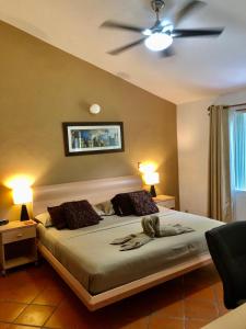 普拉亚卡门卡萨米特索罗旅馆的一间卧室配有一张带吊扇的床
