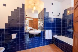 塞哥维亚Hotel Cetina Palacio Ayala Berganza的蓝色瓷砖浴室设有水槽和浴缸