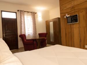 HegomaMkomazi Hotels and Camps的卧室配有一张床和一张桌子及椅子