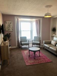 阿伯里斯特威斯Cranwell Court Apartments的客厅配有沙发和桌子