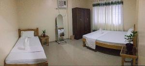 塔比拉兰Kylitas transient house- Bohol的一间卧室设有两张床、镜子和窗户