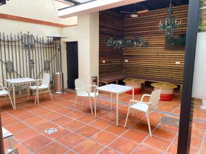 巴塞罗那BCN Urbaness Hotels Bonavista的铺有瓷砖地板,设有带桌椅的天井。