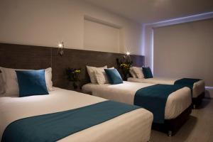 圣萨尔瓦多7hotel的酒店客房 - 带两张带蓝色枕头的床