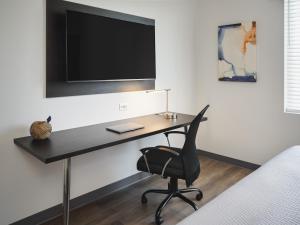 圣安东尼奥stayAPT Suites San Antonio-Lackland的一张桌子、椅子和墙上的电视