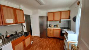 特罗姆瑟Tromso Coco Apartments in Center的厨房配有木制橱柜和不锈钢冰箱。