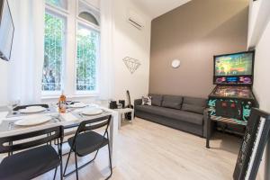布达佩斯happy home JOY - apartment with free Pinball Machine的客厅配有桌子、电视和沙发。