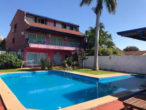 伊瓜苏港Guembe al Rio Hostel的大楼前带游泳池的房子