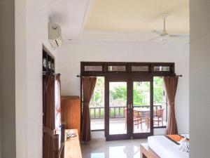 乌布Putra Bisma Guesthouse的一间设有通往庭院的门的房间