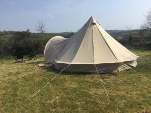 MellionnecEcoCamping d Hacadour的草原上的帐篷
