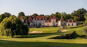 莫内斯捷维杰城堡酒店的一座带池塘的高尔夫球场上的古老豪宅