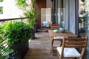 米兰Madeleine apartments - Appartamento di charme的庭院设有木桌、椅子和植物