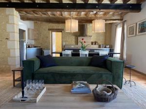 Cour-Maugis-sur-HuisneChambres d'hôtes du Bistrot des écuries的一间带绿色沙发的客厅和一间厨房