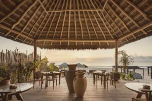 图卢姆Hotel Ma'xanab Tulum的海滩上的餐厅,配有桌椅