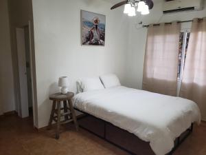 拉塞瓦Paradise Found的一间卧室配有一张床和一张凳子,墙上挂着一张照片