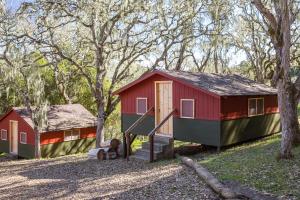 卡梅尔瓦利The Camp at Carmel Valley的树林里的一个红绿色的小房子