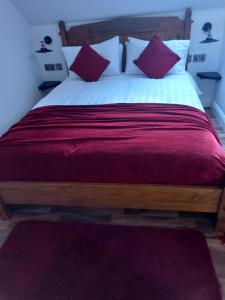 BessbrookDerrywilligan Guest Accommodation的一间卧室配有一张带红色和白色枕头的大床