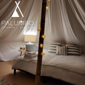 卡扬贝Palumbo Glamping & Villas的一间卧室设有一张床和一张桌子的天蓬
