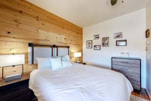 帕戈萨斯普林斯Riverfront Lodge的卧室配有白色的床和木墙