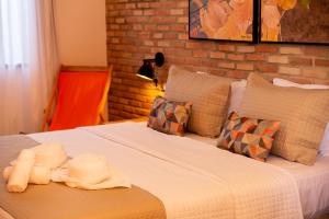 CoqueiroPousada das Flores的一间卧室配有带白色床单和枕头的床。